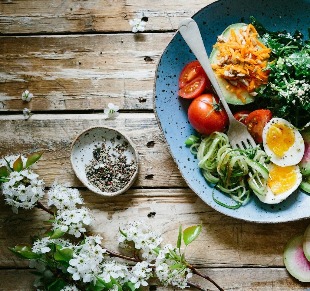 poached egg with vegetables and tomatoes on blue plate